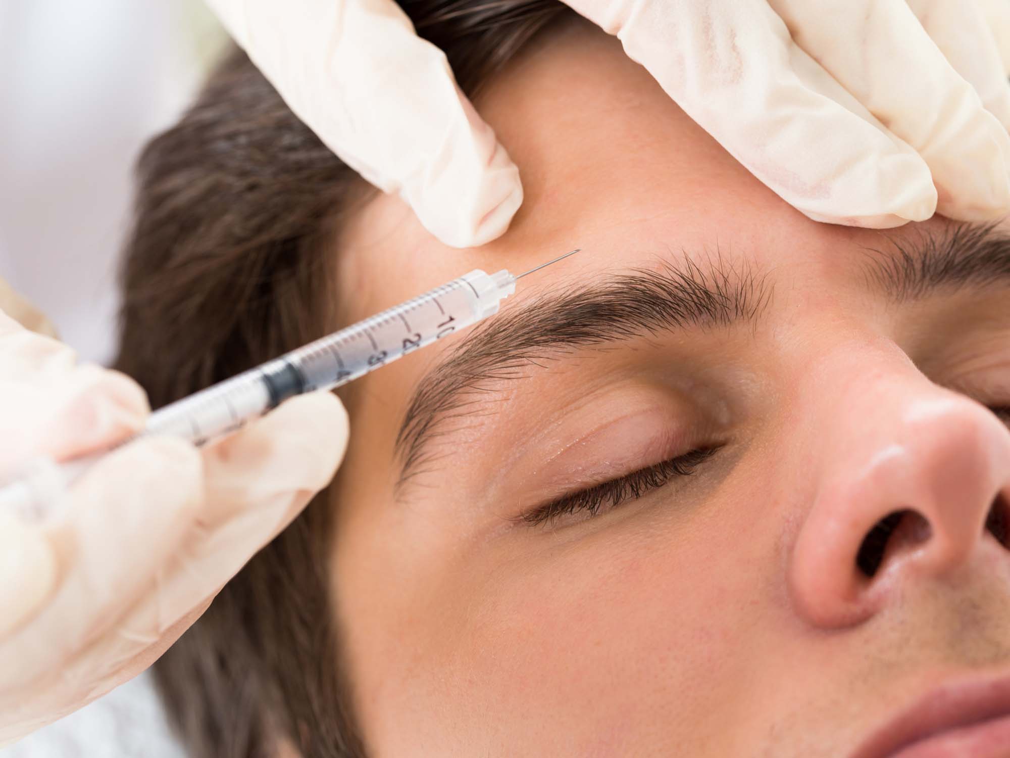 Young Man Having Botox Treatment At Beauty Clinic