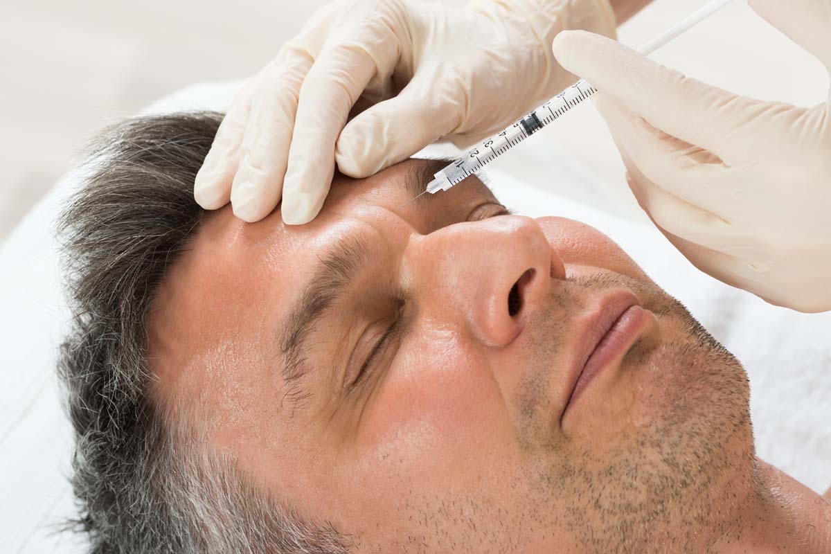 Man Receiving Cosmetic Injection With Syringe