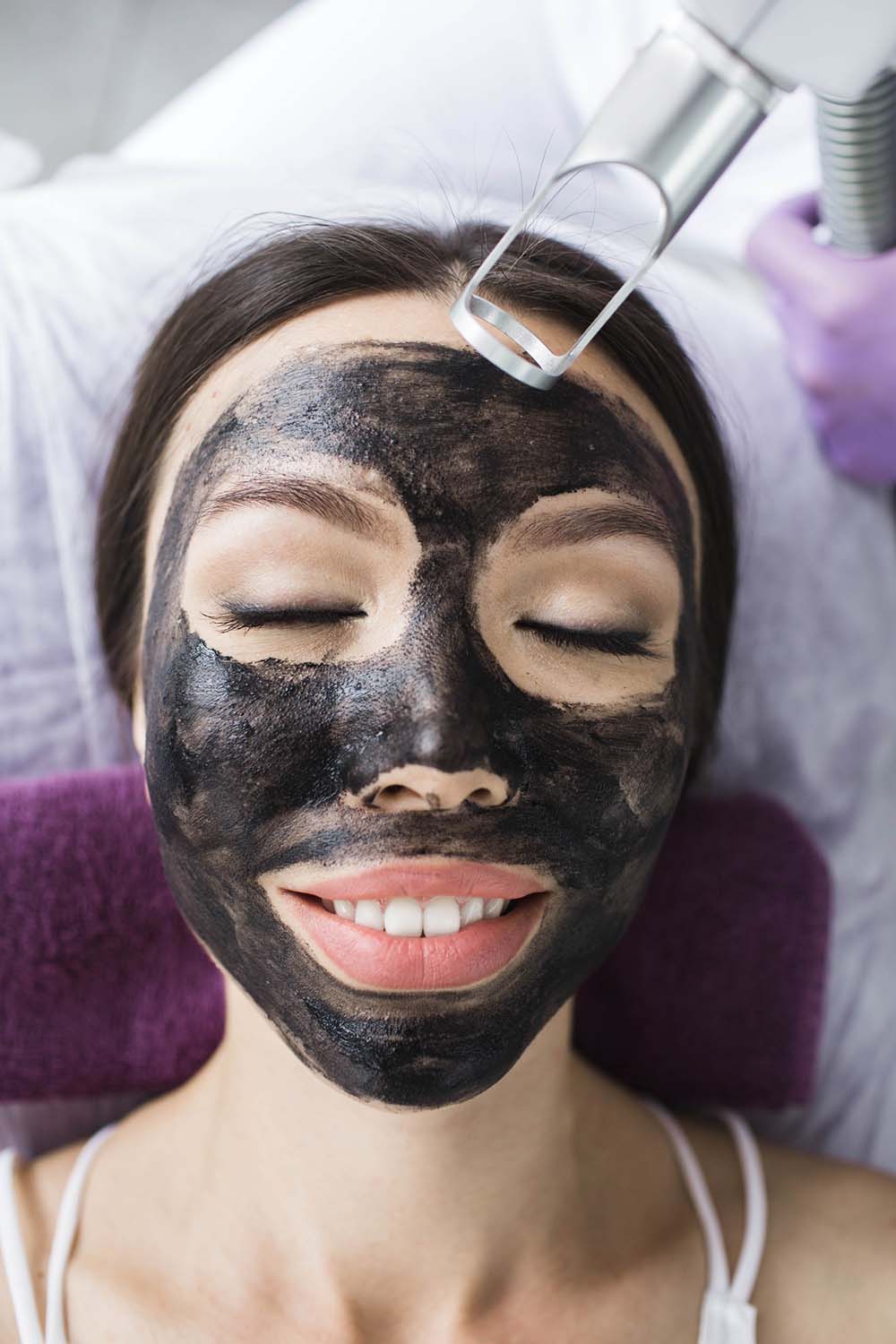 Cute asian woman gets a face peeling procedure in a beauty salon. Skin care