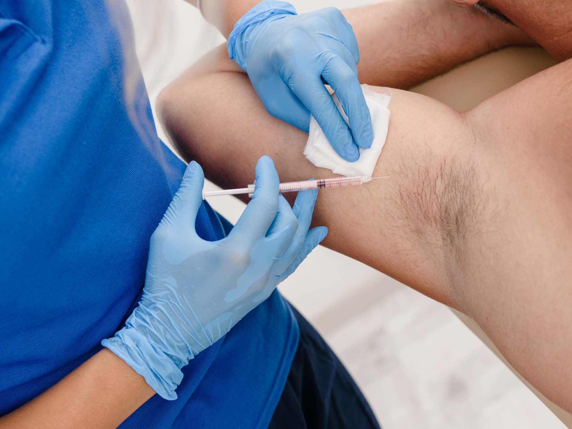 Closeup of female doctor making injections in armpit against hyperhidrosis for man