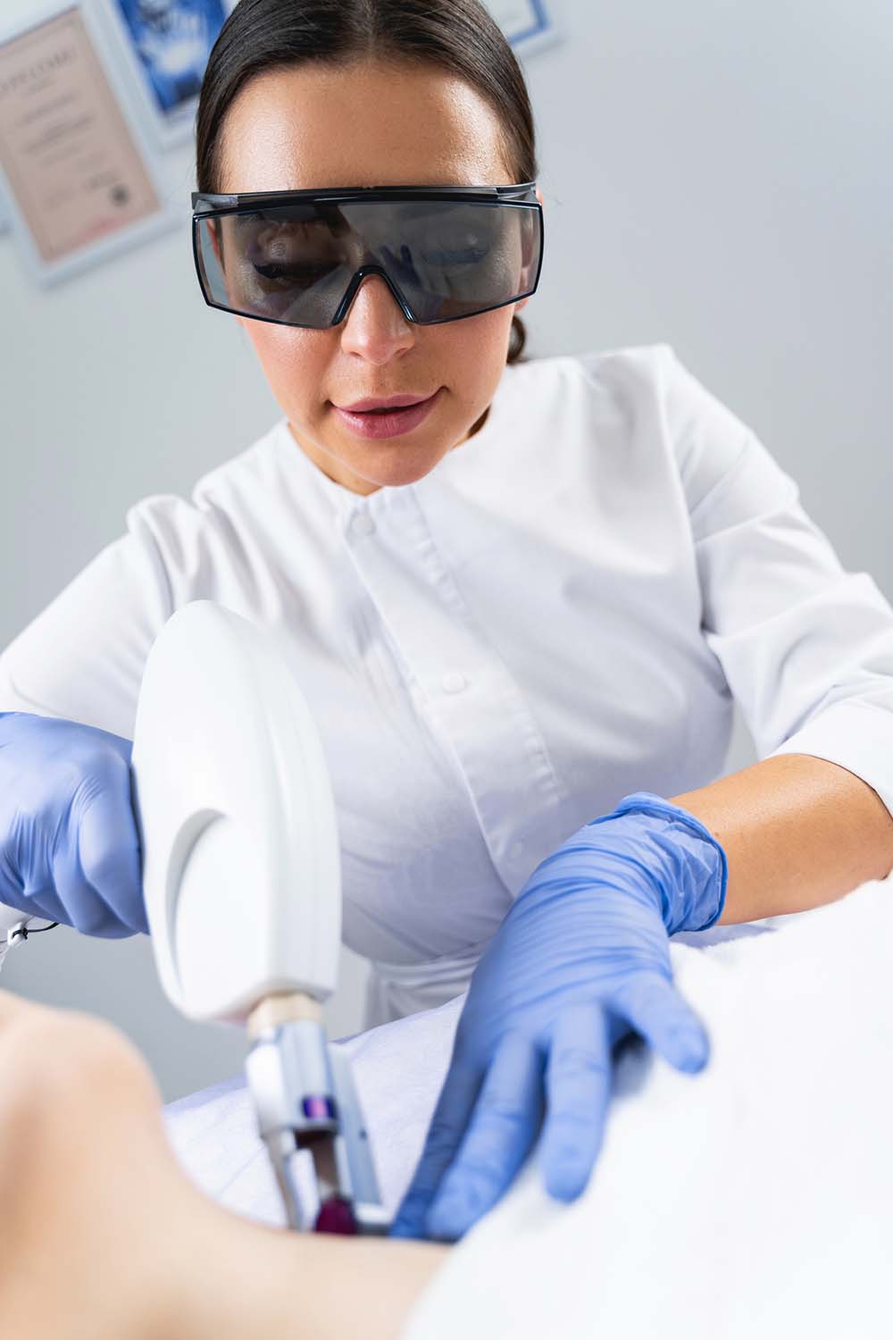 Dermatologist smoothing fine lines on her patients neck Dermatologist smoothing fine lines on her patients neck