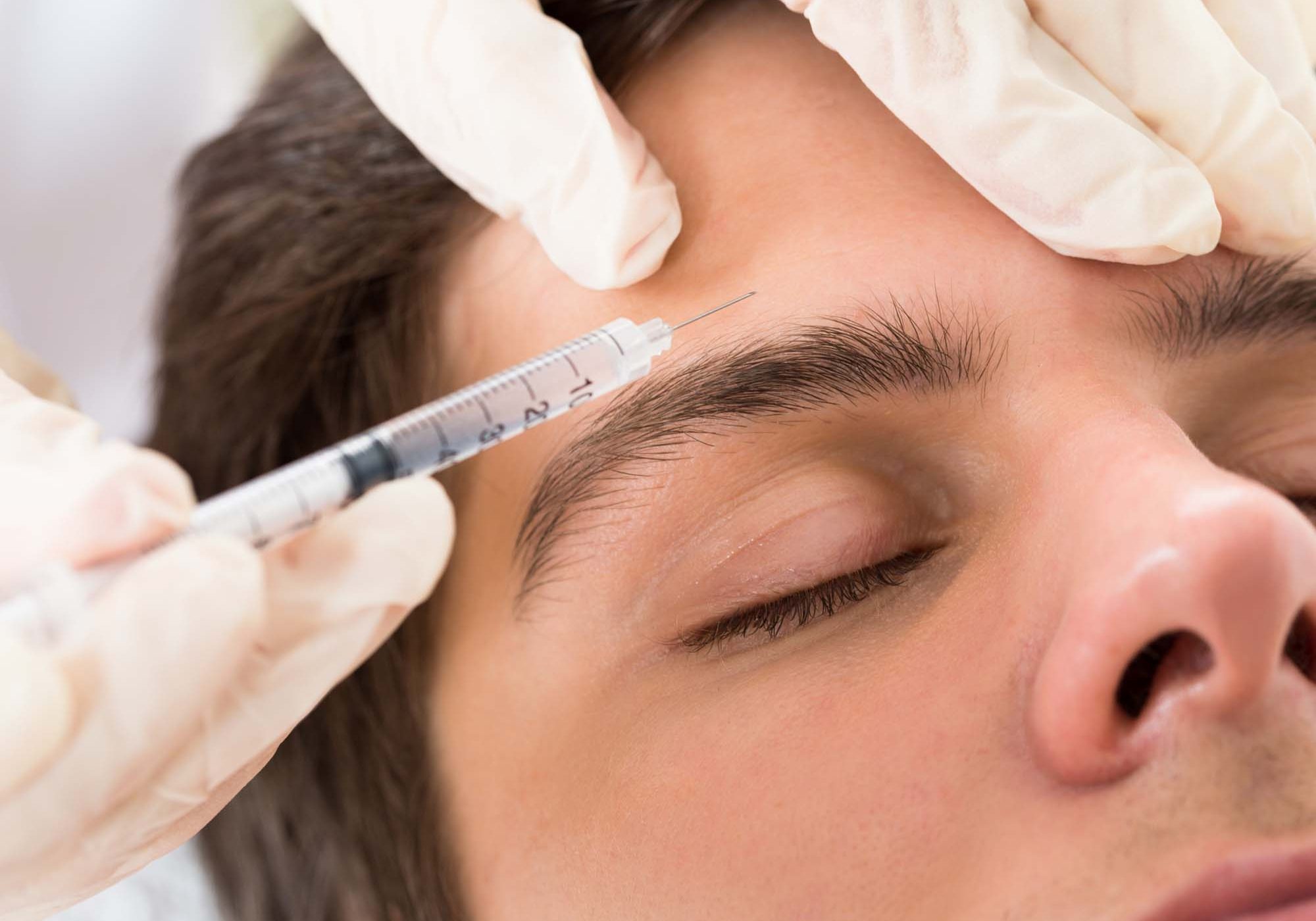 Young Man Having Botox Treatment At Beauty Clinic