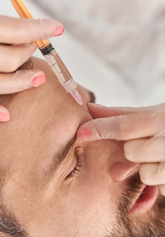 Close up makes mesotherapy injections to young man. Treatment of male by a beautician for tightening and smoothing wrinkles on the face skin Close up makes mesotherapy injections to young man. Treatment of male by a beautician for tightening and smoothing wrinkles on the face skin