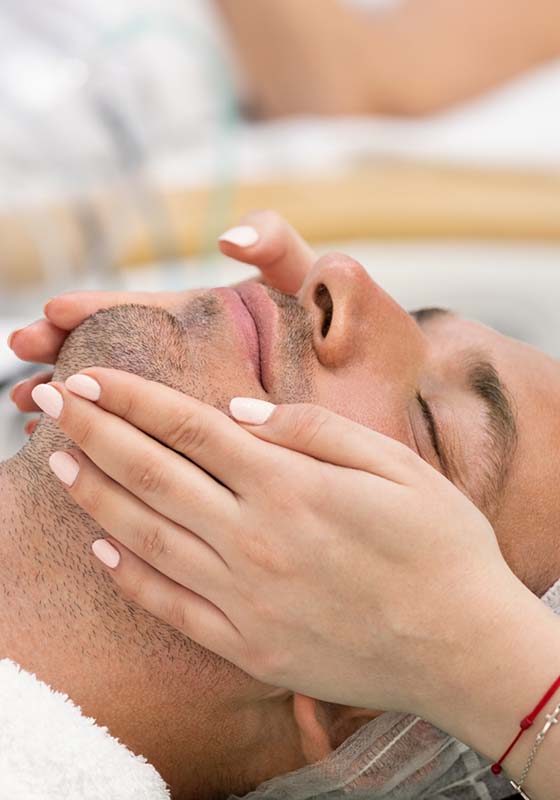 Young handsome man receiving facial massage and spa treatment